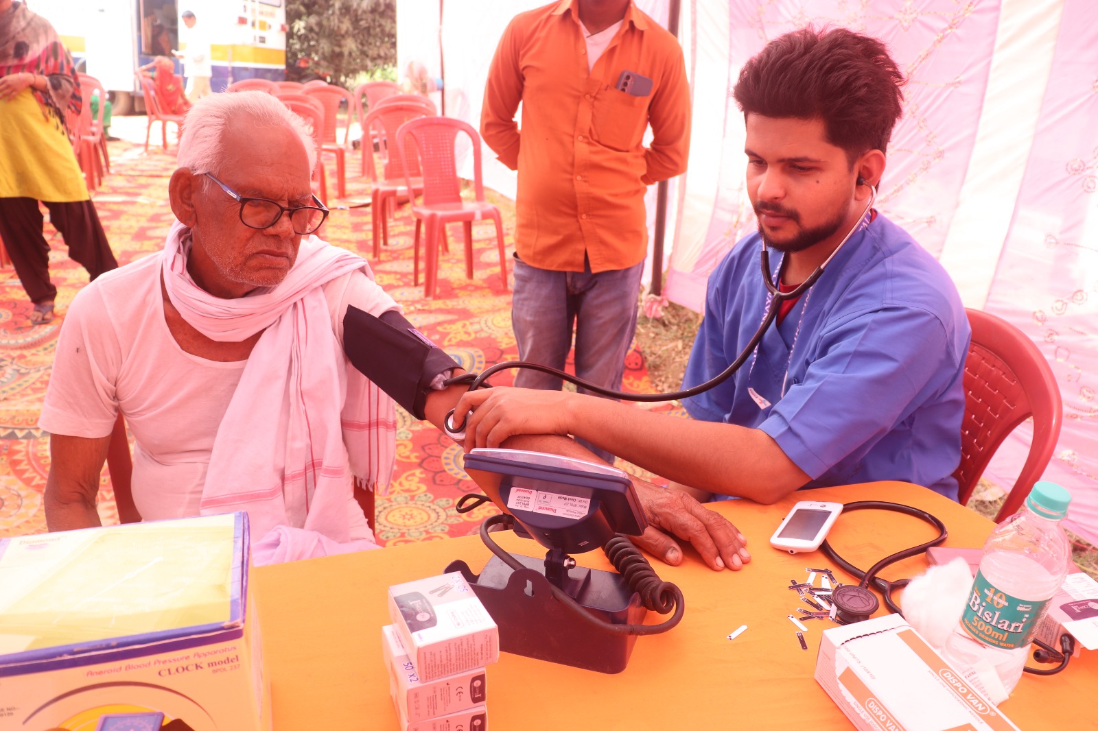 Elderly patient having blood pressure checked by SPHC volunteer